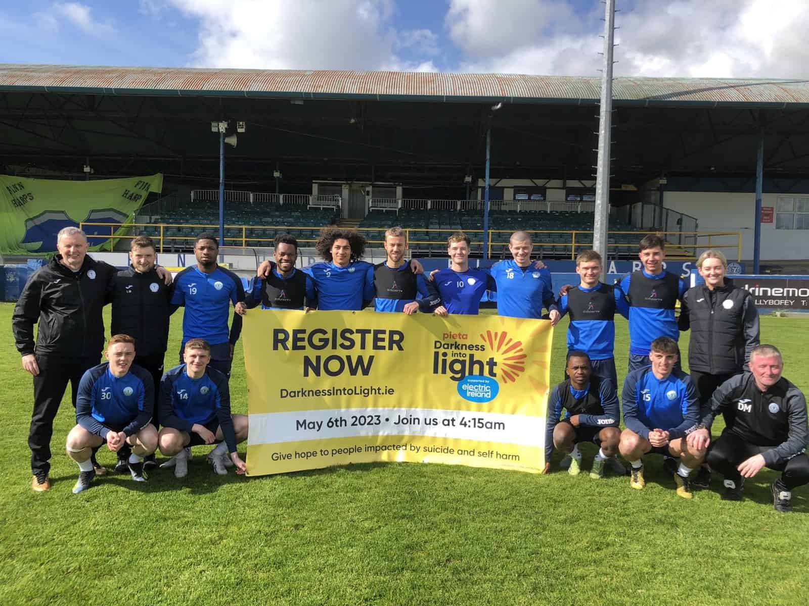 The Harps Squad Holding a Darkness into Light banner at Finn Park